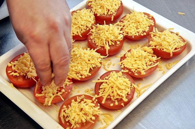 トマトにチーズを振りかける写真