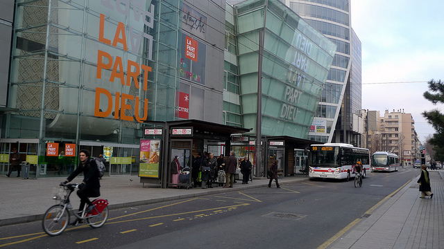 リヨン市内中心地で電車の前を自転車に乗った人が走る様子。